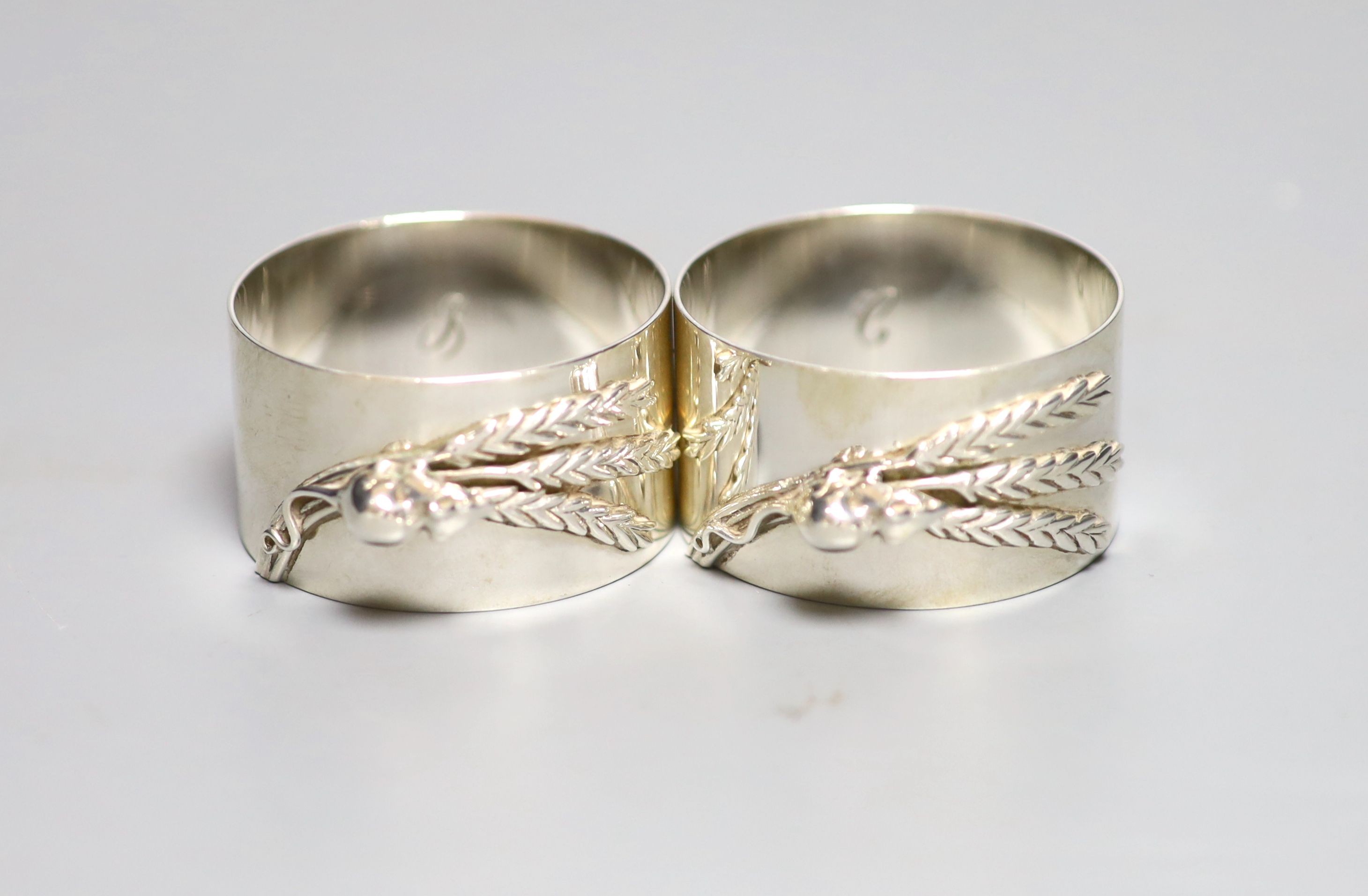 A modern pair of silver napkin rings cast with mice and wheatsheaf, by Sarah Jones, London, 1986, 45mm, 84 grams.